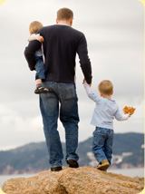 Man with kids overlooking the ocean and hills